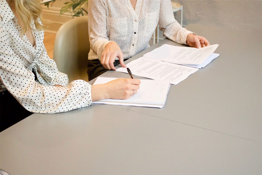 Cropped stock photo of two businesswomen at a desk